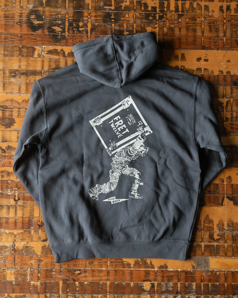 This heavy weight asphalt hoodie by FRET12 features a screen printed graphic of the String Thing carrying a road case.